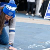 Emily Miller chalks at the tailgate